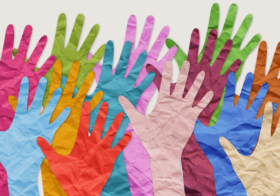 A portrait of painted raised hands. They are multicolored
