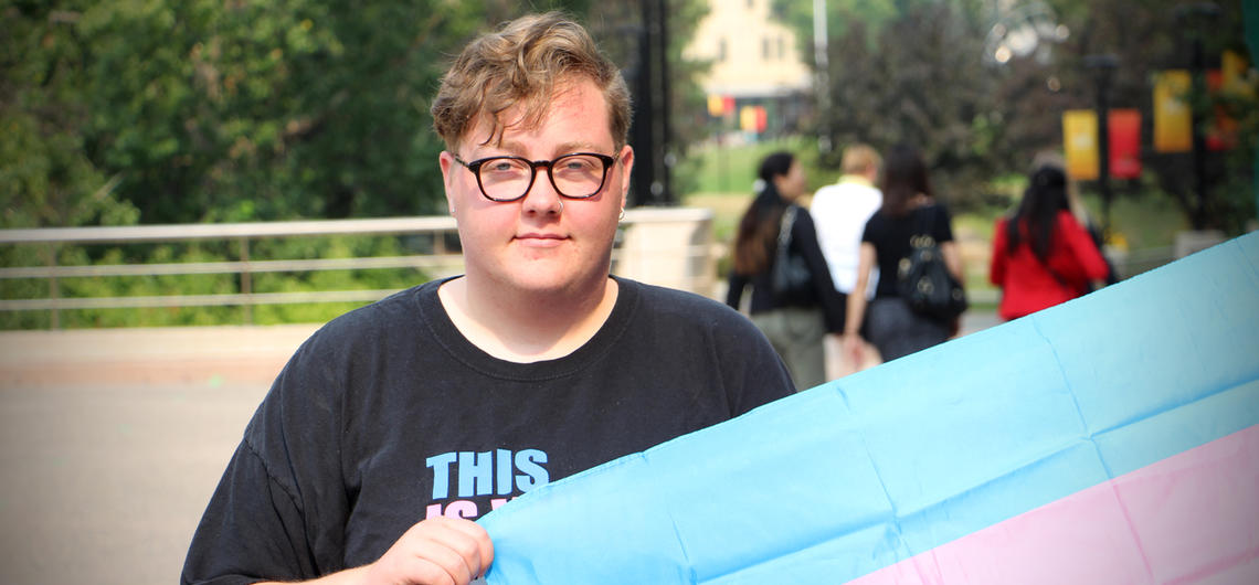 Beck Paterson holds the trans flag. Paterson and fellow social work students, along with alumni, faculty, field instructors and friends will participate in this year's Pride parade. 