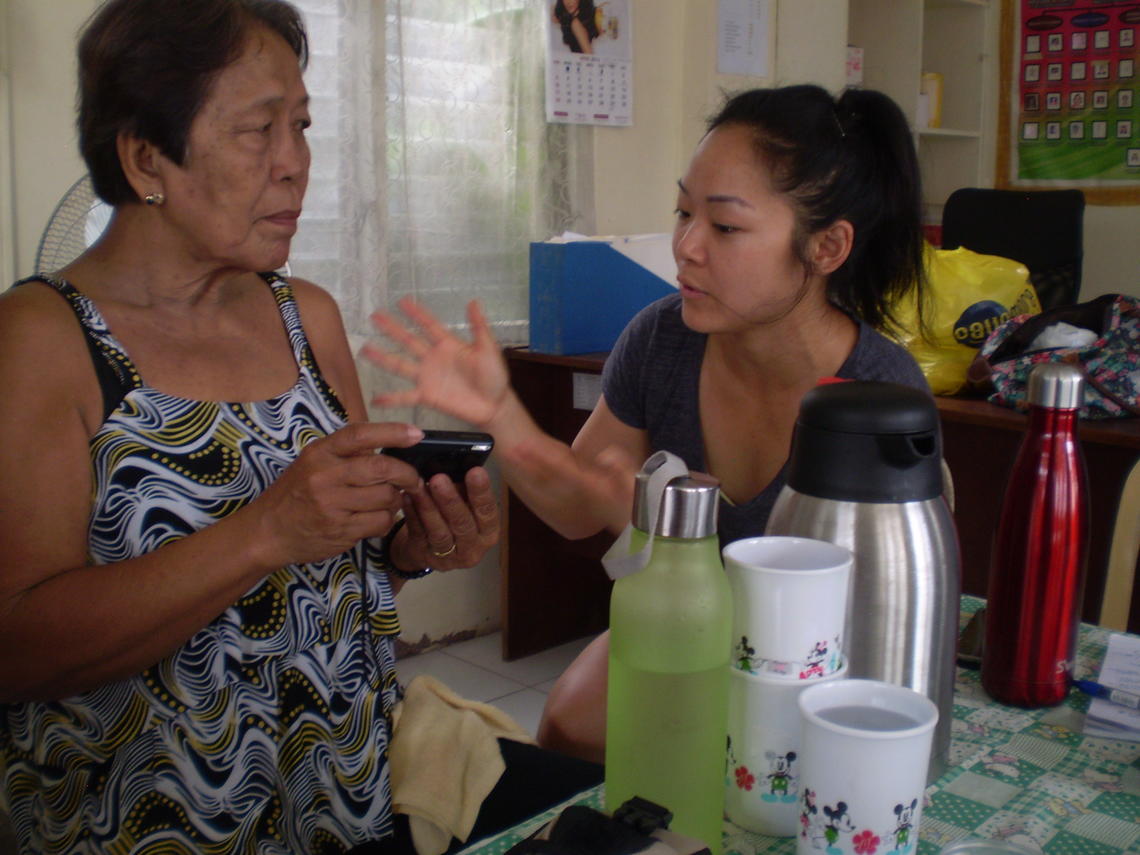 Crystal Kwan teaches a participant how to use the camera to take photos and video as part of data collection.