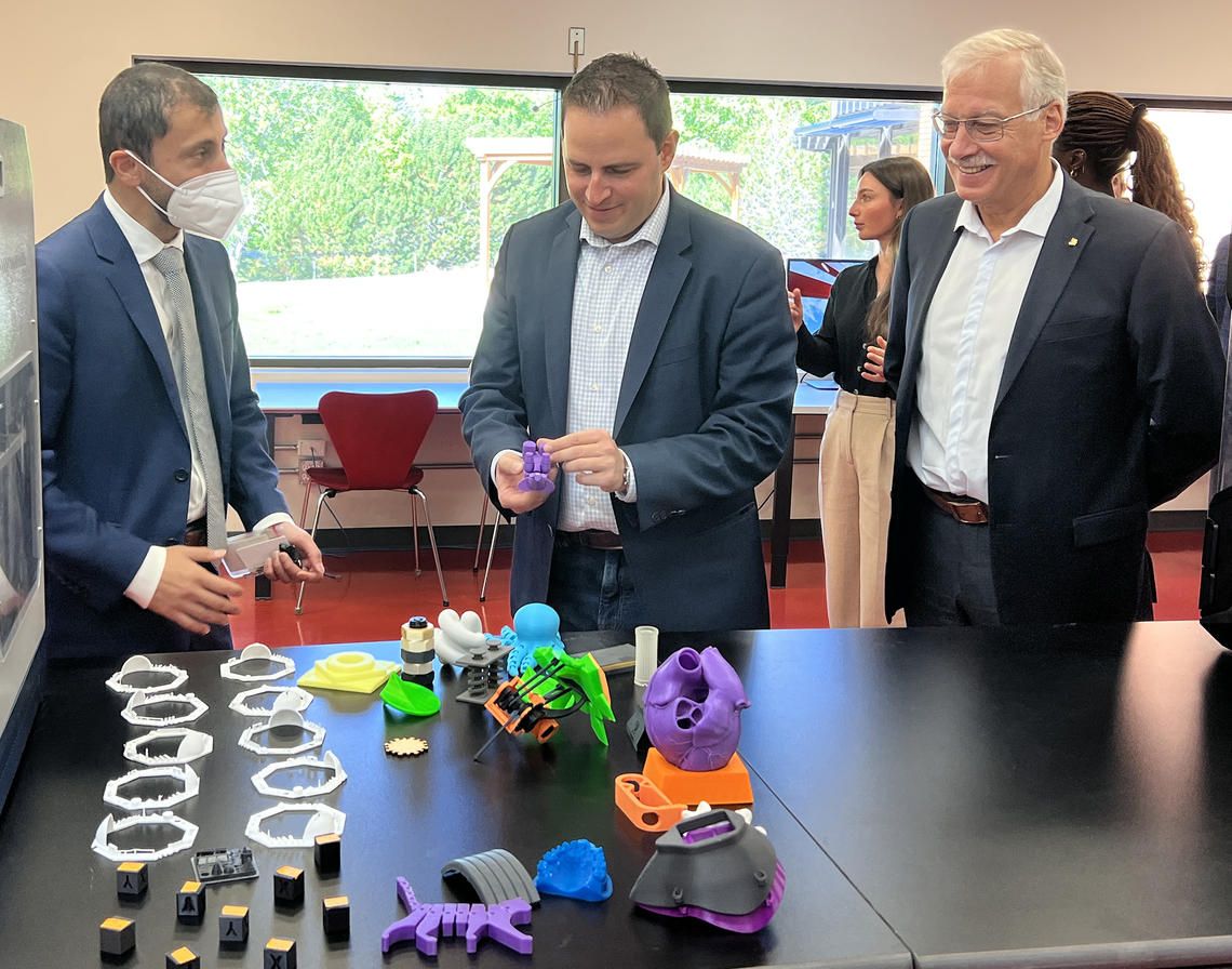 Nima Najand, PhD (Director, LSIH) discusses lab equipment at LSIH with Hon. Demetrios Nicolaides and vice-president (research) André Buret