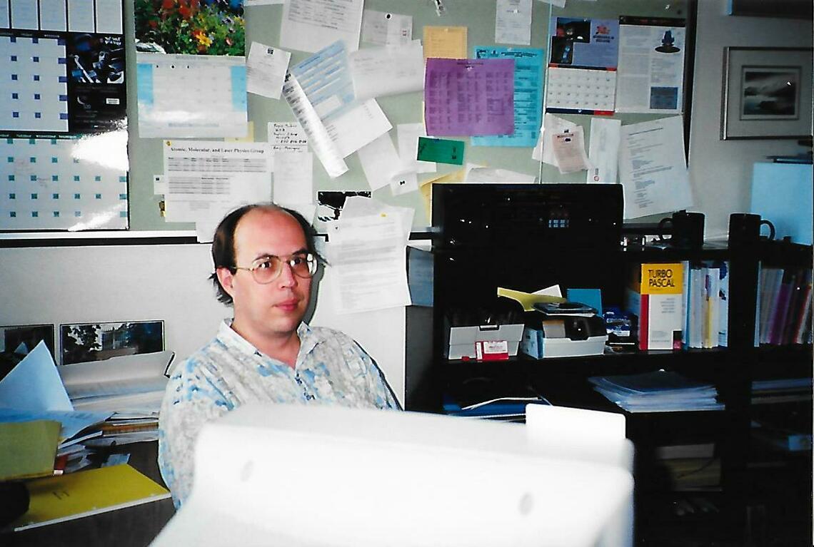 A young Rob Thompson sits in a room full of papers