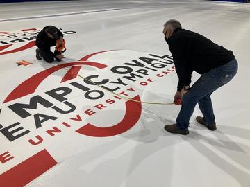 Oval team painting logos on the ice