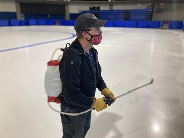 Oval team member prepares to paint lines on the ice