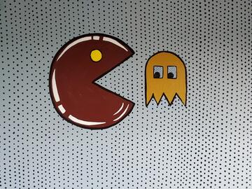 An illustration of a red pacman eating a yellow ghost