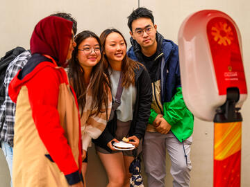 UCalgary community members taking photos at the Cosmo Photo Booth station.