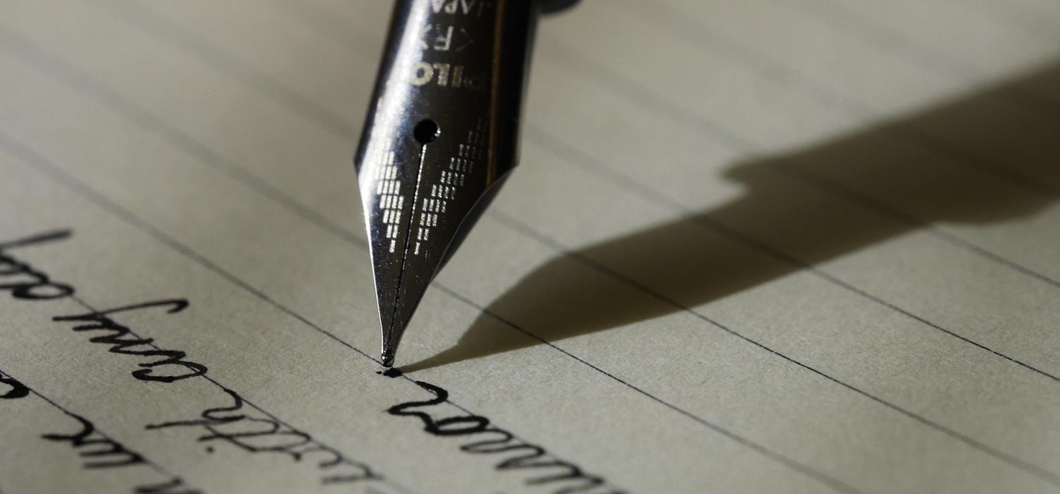 Closeup of pen nib writing on paper