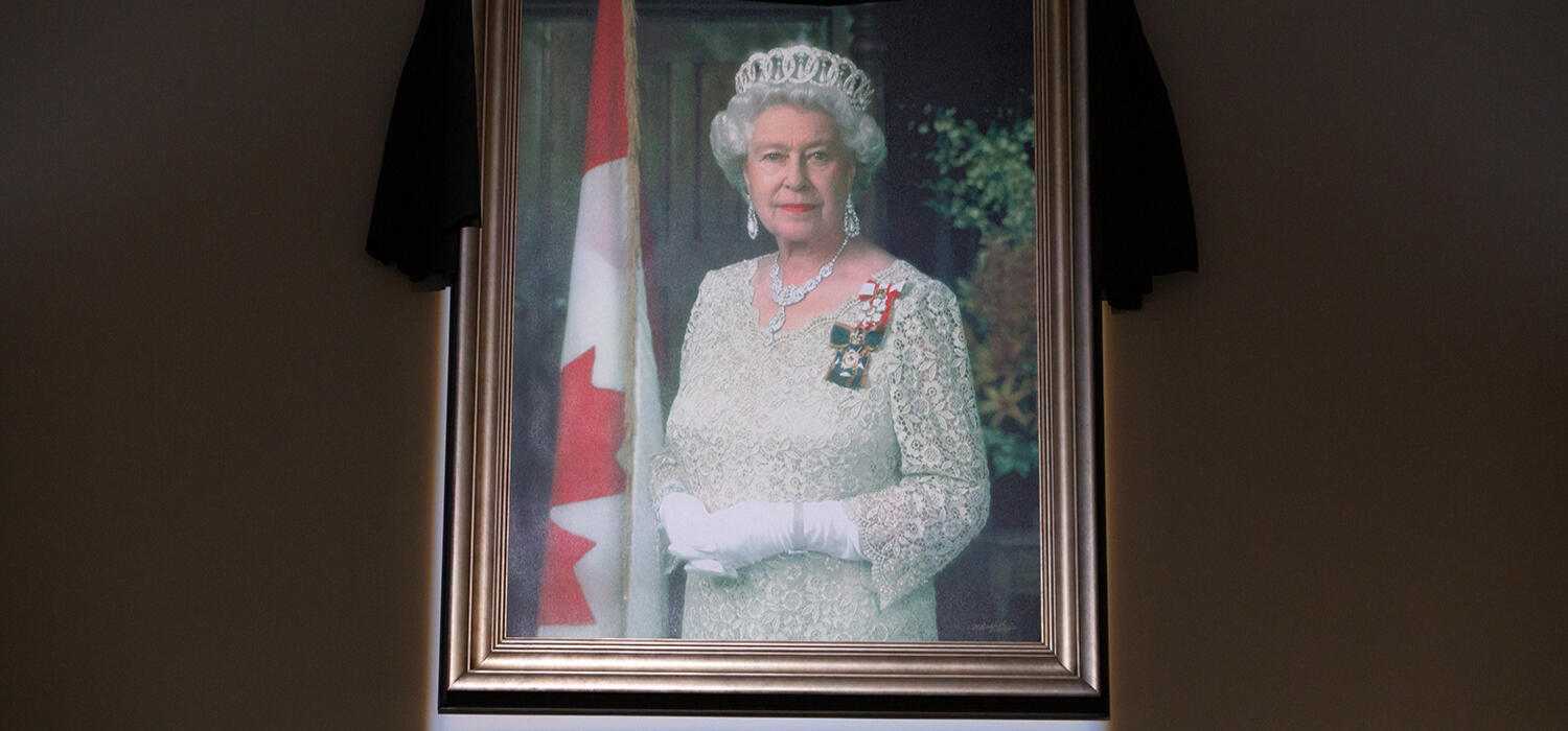 Draped in black, an official portrait of Queen Elizabeth II hangs in the Atrium at The Military Museums of Calgary.