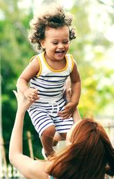 woman holding up little kid