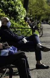 Older adult on park bench with mask on