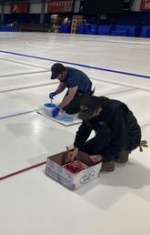 Olympic Oval operations team prepare the ice by painting lines on it