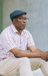Uchechukwu Peter Umezurike, sitting, looking into the distance.