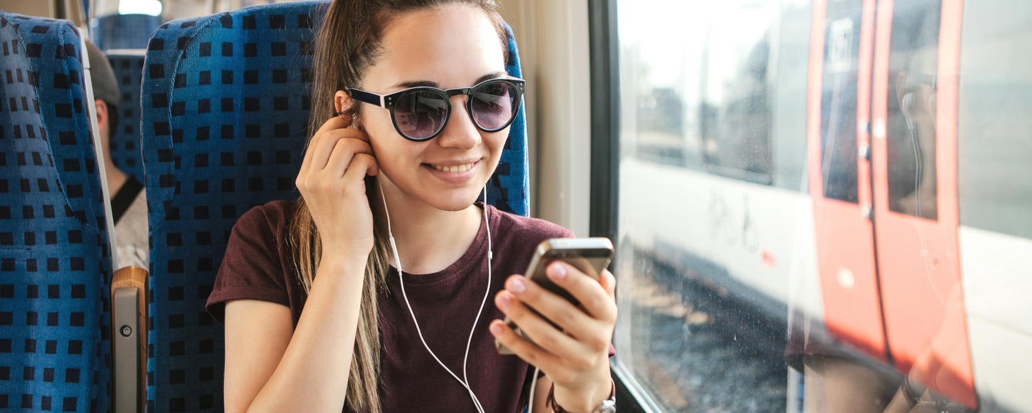 Woman listening to podcast on a train