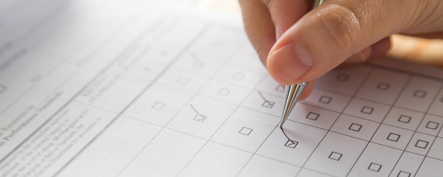 pen filling out paper survey image