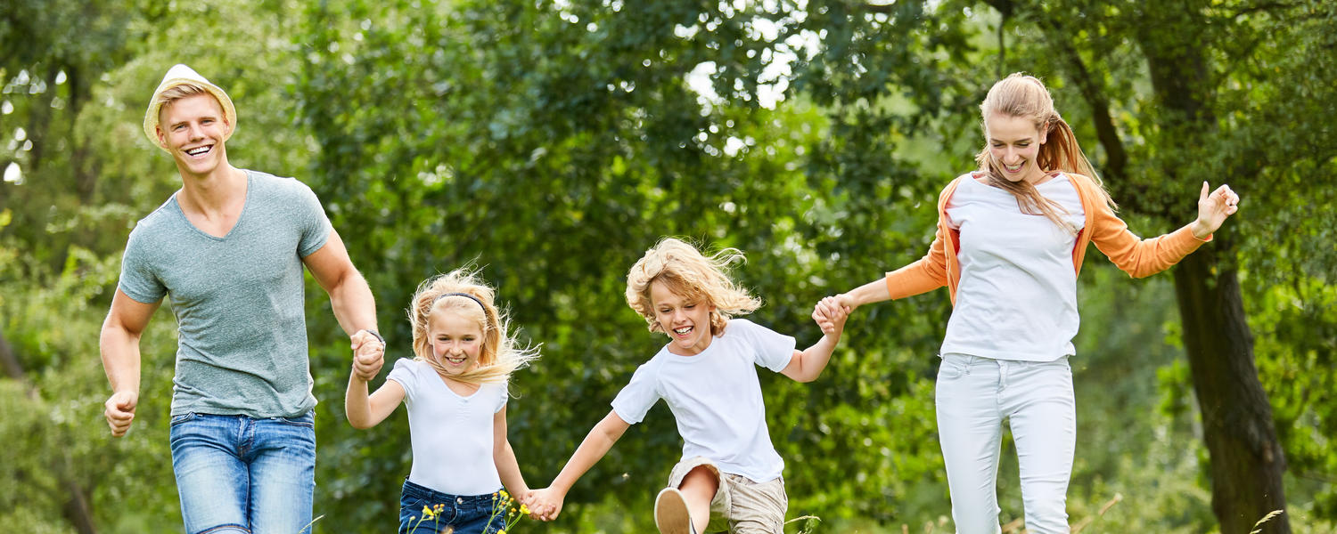 Family running and playing in woods