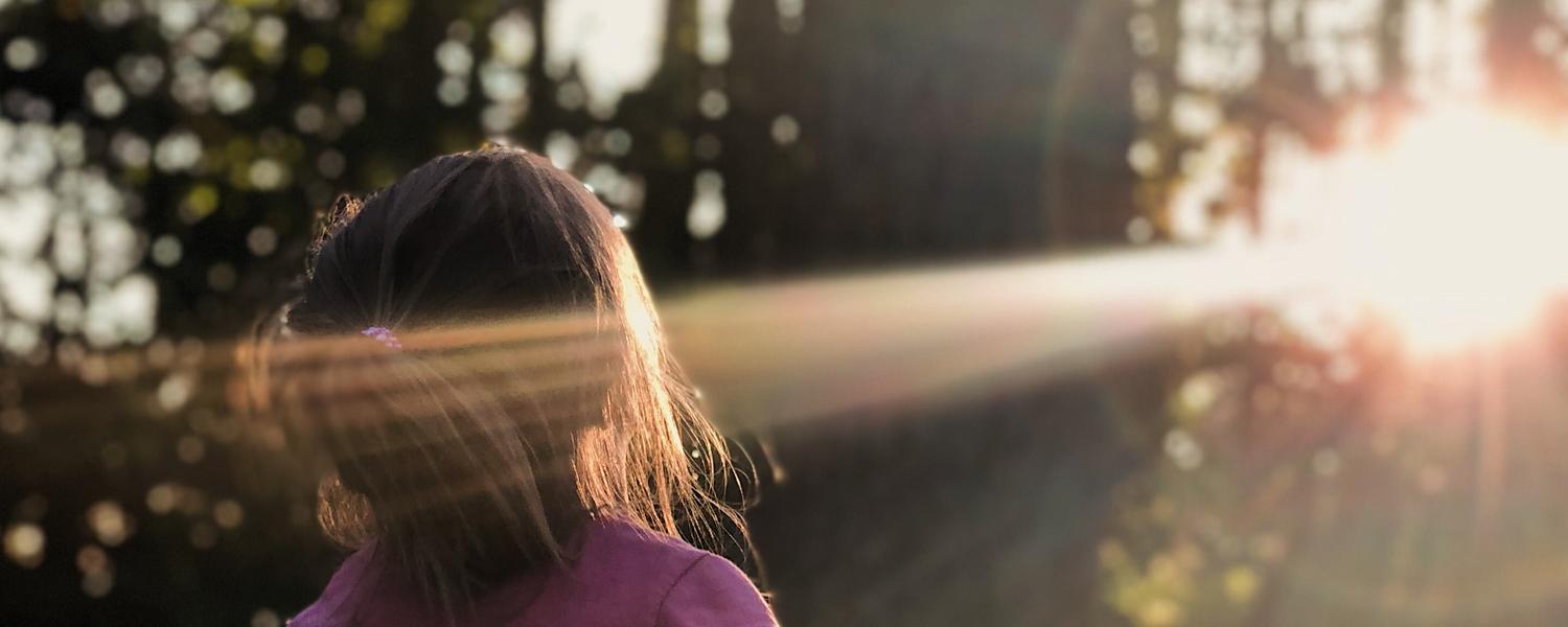 Child bathing in woodland sunlight