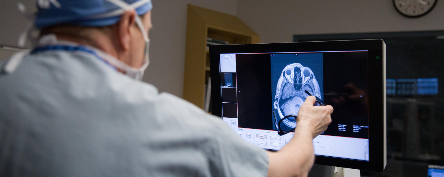 Neurosurgeon looking at scanned image of brain