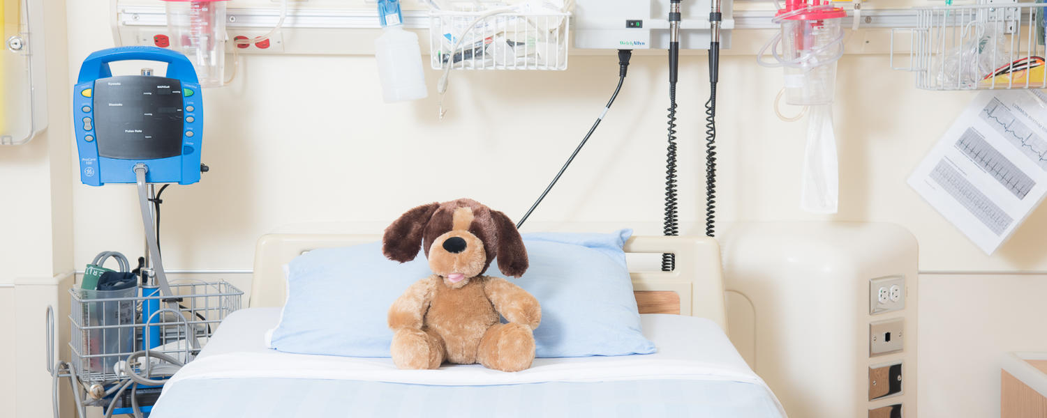 teddy bear on top of hospital bed
