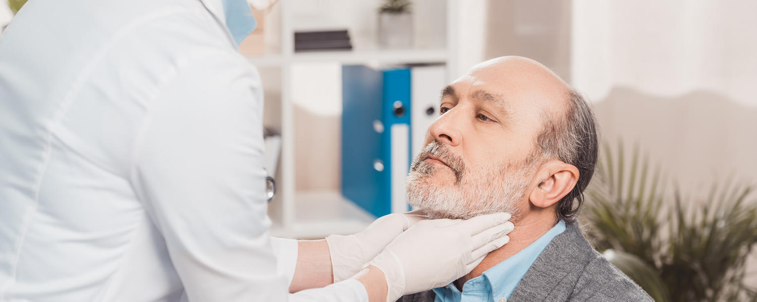 Man having neck examined by physician