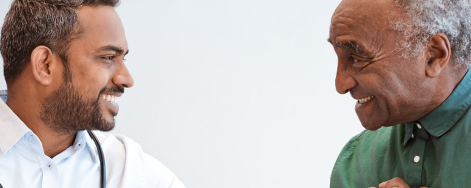 healthcare provider and patient smiling at each other and clasping hands