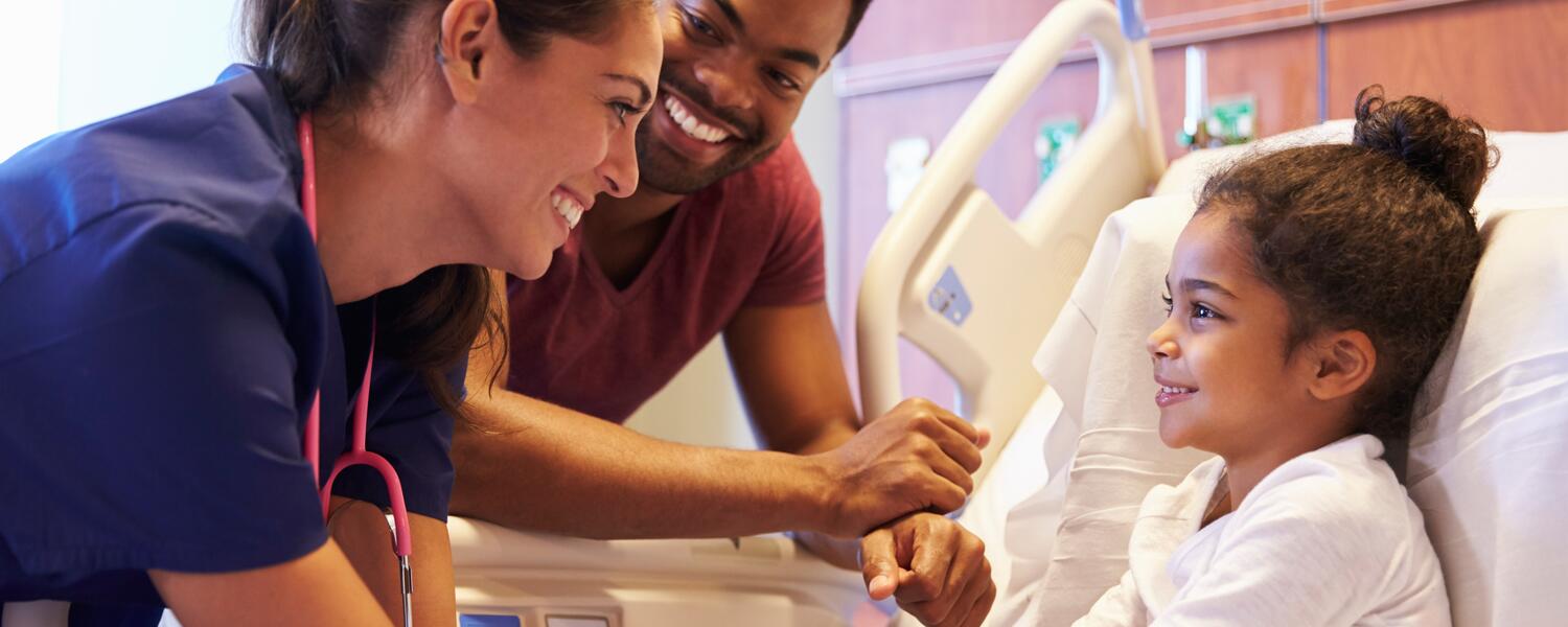 Parent, doctor, and child in hospital room.