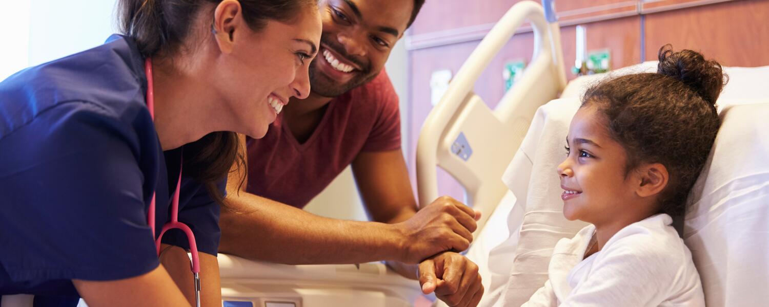 Parent, doctor, and child in hospital room.
