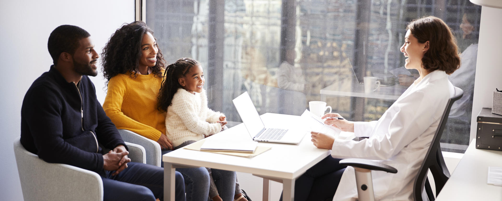 Parents with daughter sitting across from their doctor.