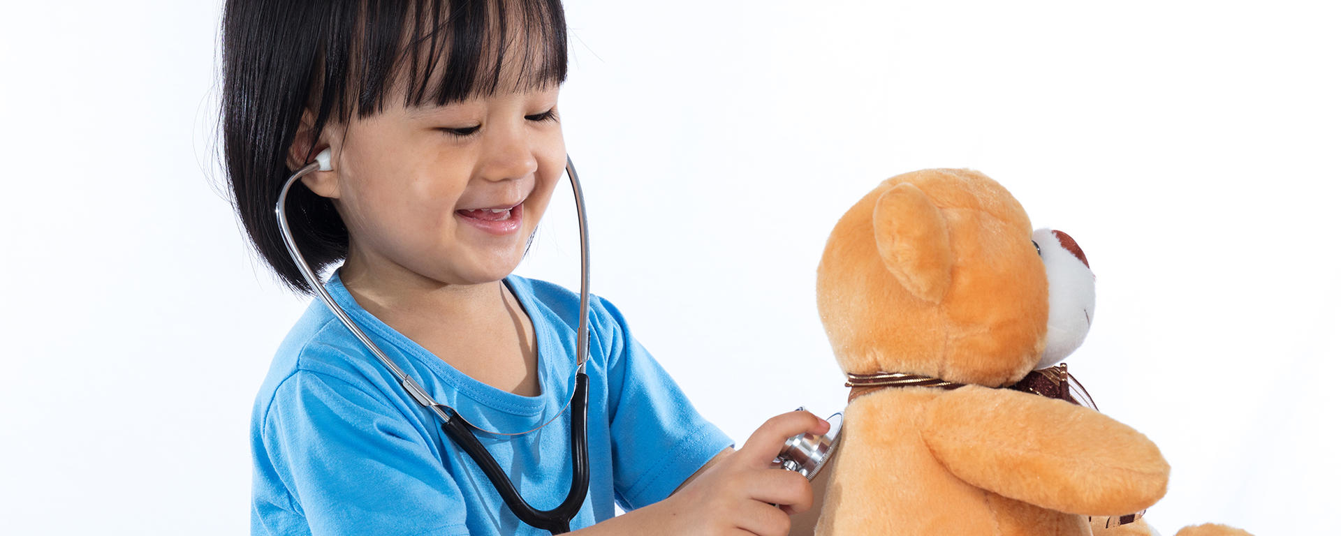 girl playing doctor with toy bear