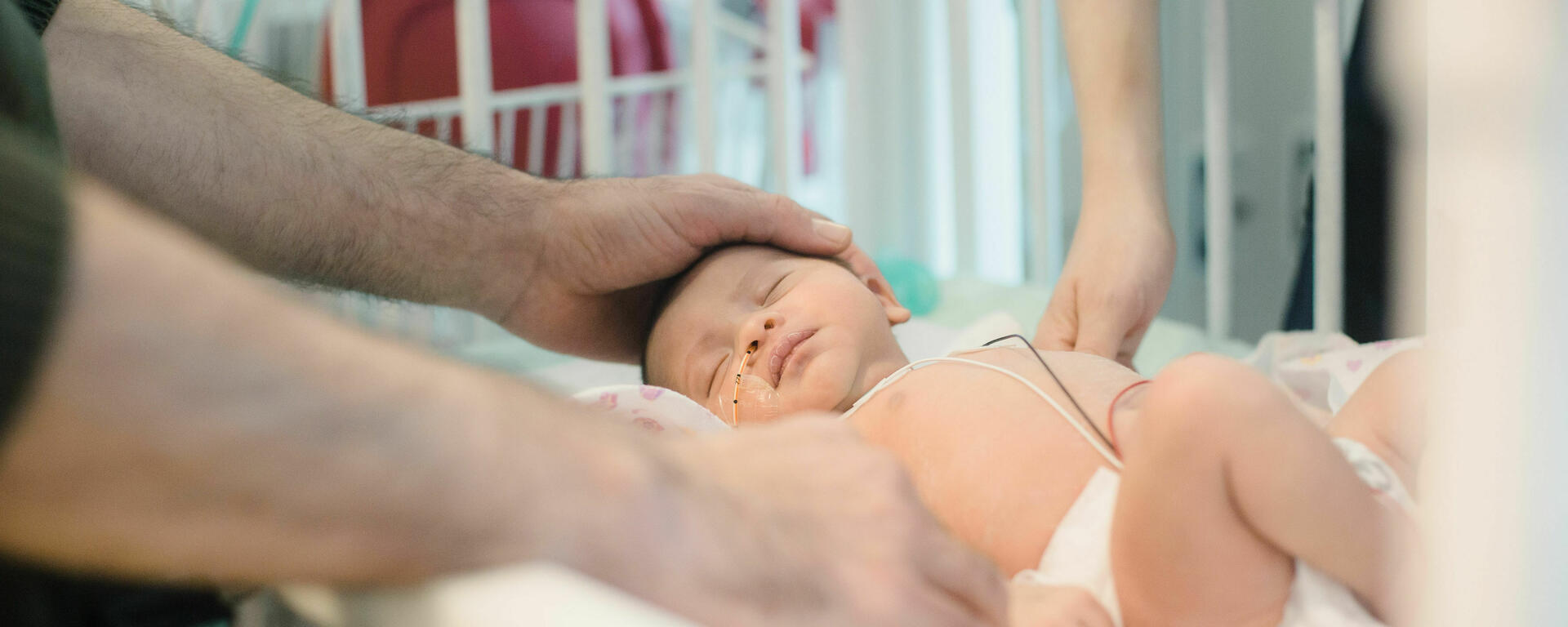 parents with hand on infant baby