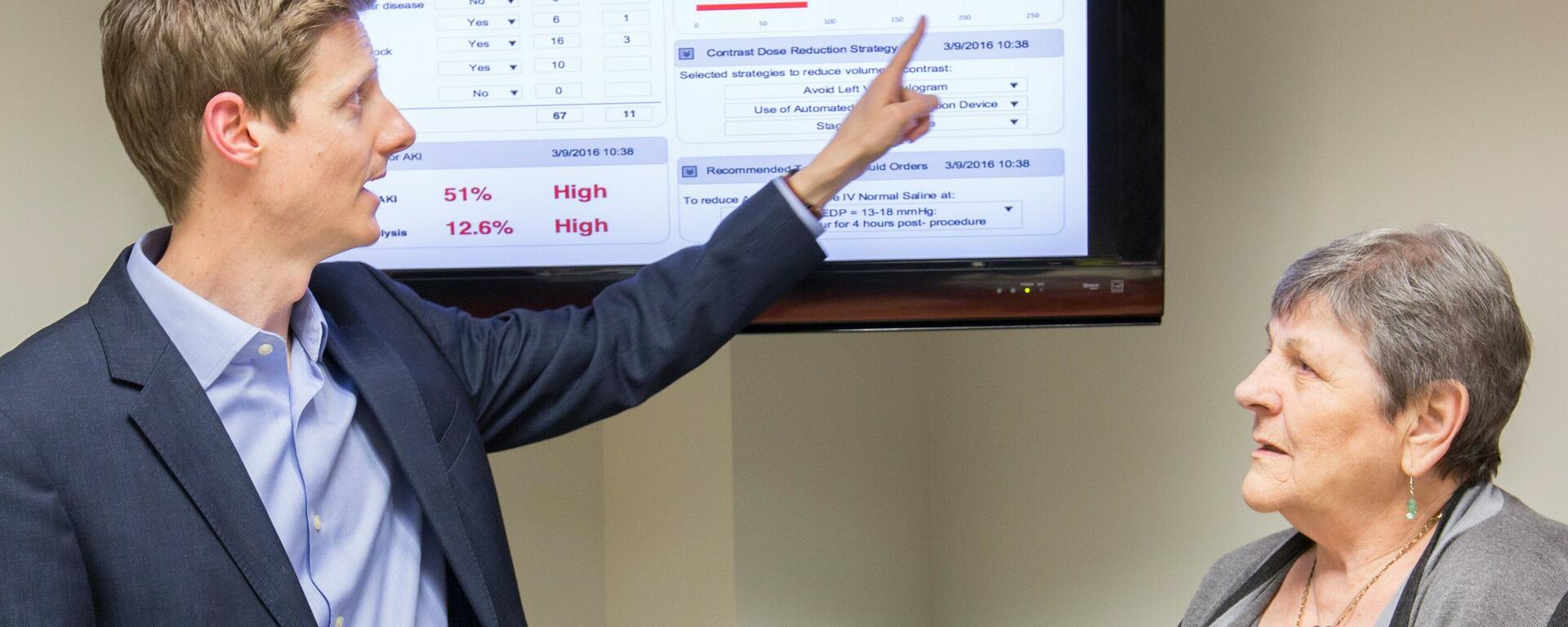 photo of Dr. Matthem James showing a patient a dashboard