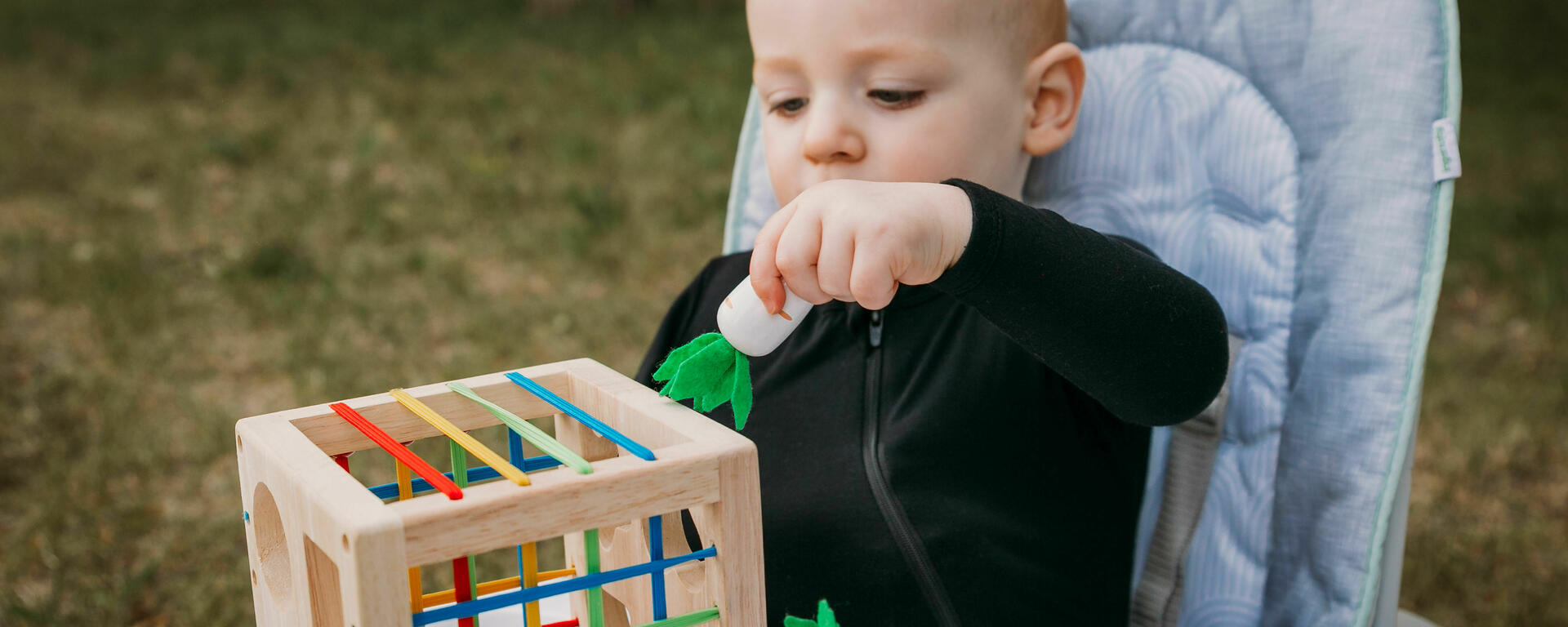 young child placing toy in box
