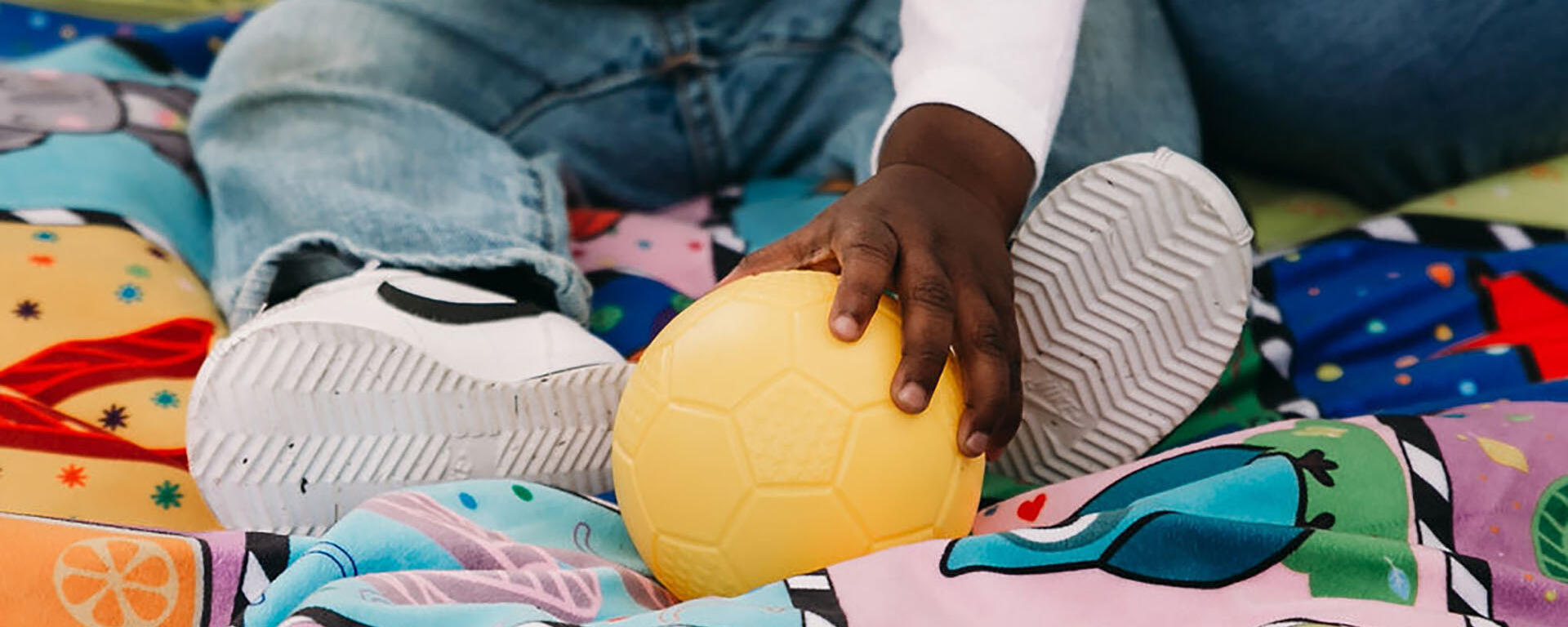 child hand grabbing ball