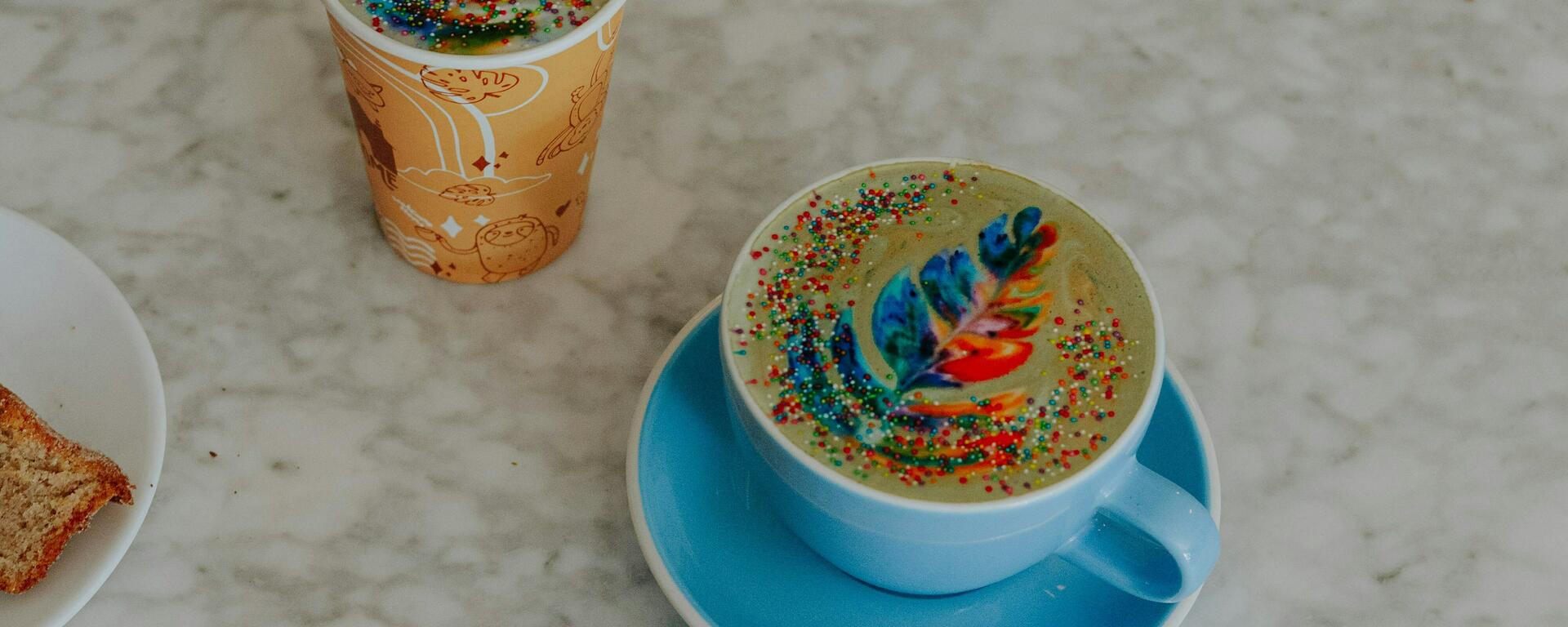 Coffee in cups and a cell phone on a bar