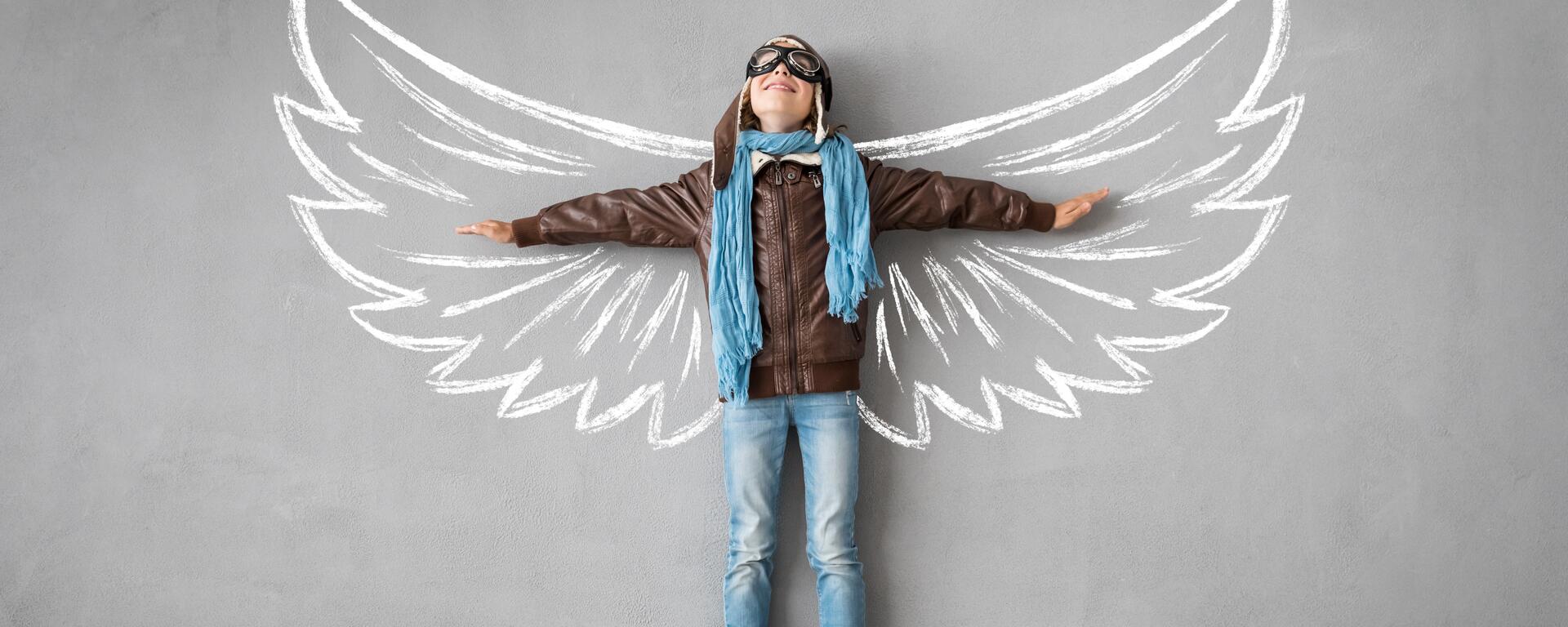 Boy with wings drawn on a wall