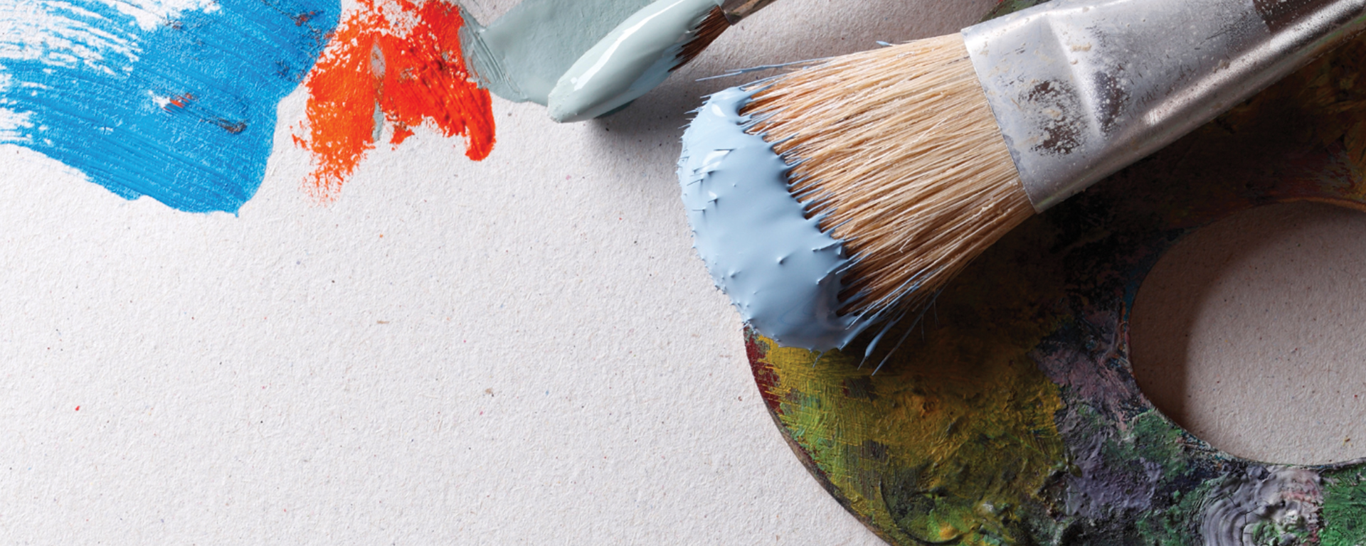 background image of paint splashes, art pallet and paintbrush