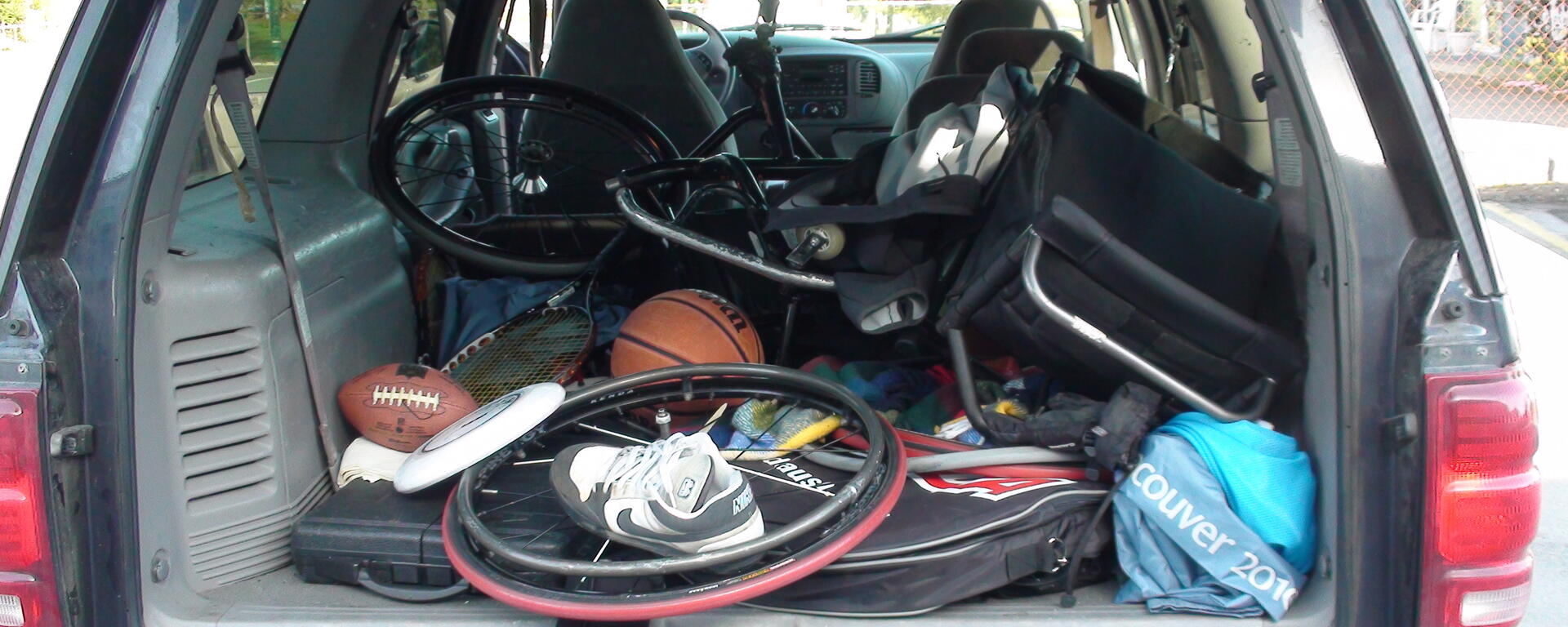 image of adapted equipment, mostly wheelchair basketball, in the trunk