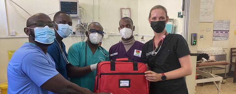 a group of five people standing holding emergency air medical equipment
