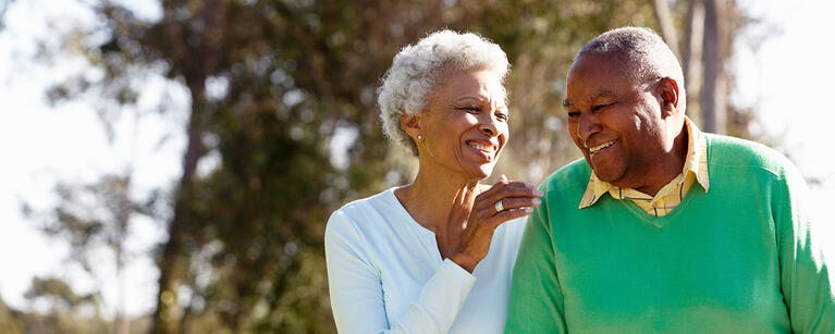 smiling woman and man walking together outside