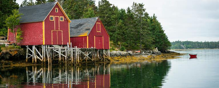 Two red houses next to a lake