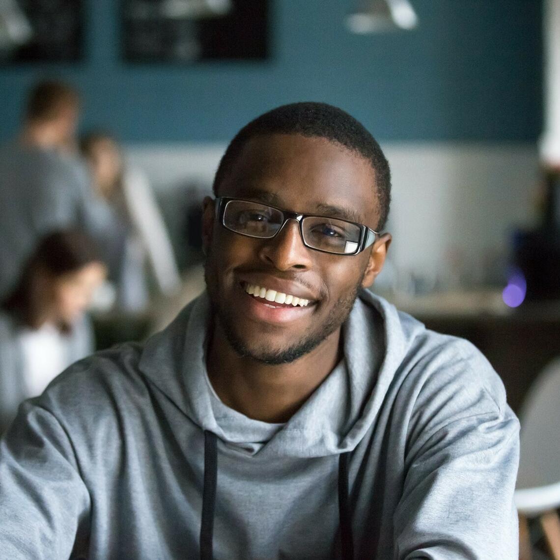 Student sitting down in the classroom and smiling at the camera
