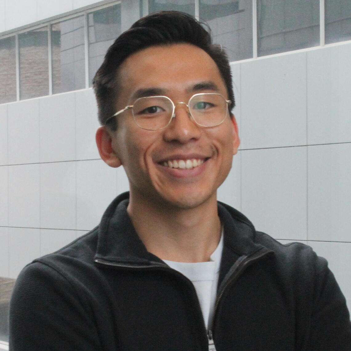 Alvin Pharm, Master's Student, smiling in a professional headshot with a hallway for a background