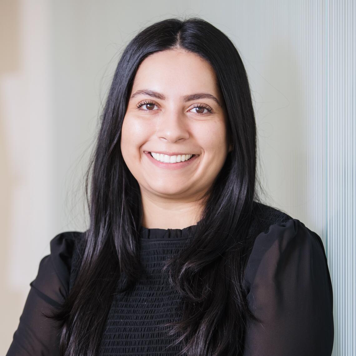 Nabilah Gulamhusein, PhD Candidate, smiling in a professional headshot with a blurred background