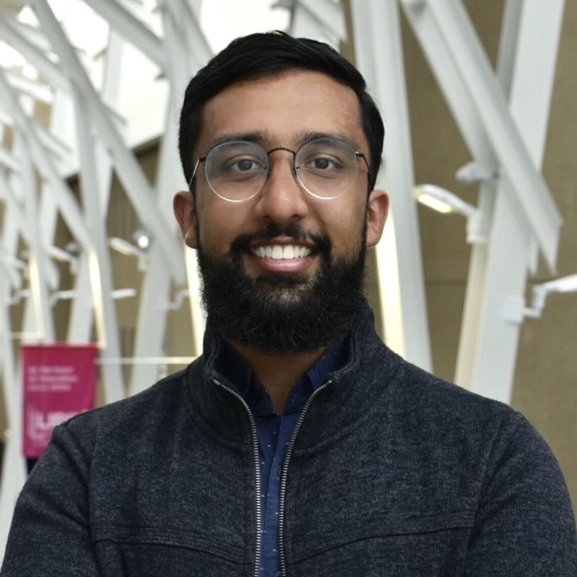 Brandon Patter, PhD Candidate, smiling in a professional headshot with a hallway background