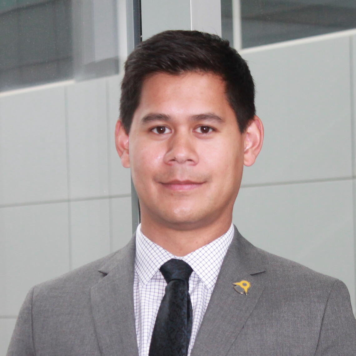Daniel Sadler, Master's Student, smiling in a professional headshot with a hallway for a background