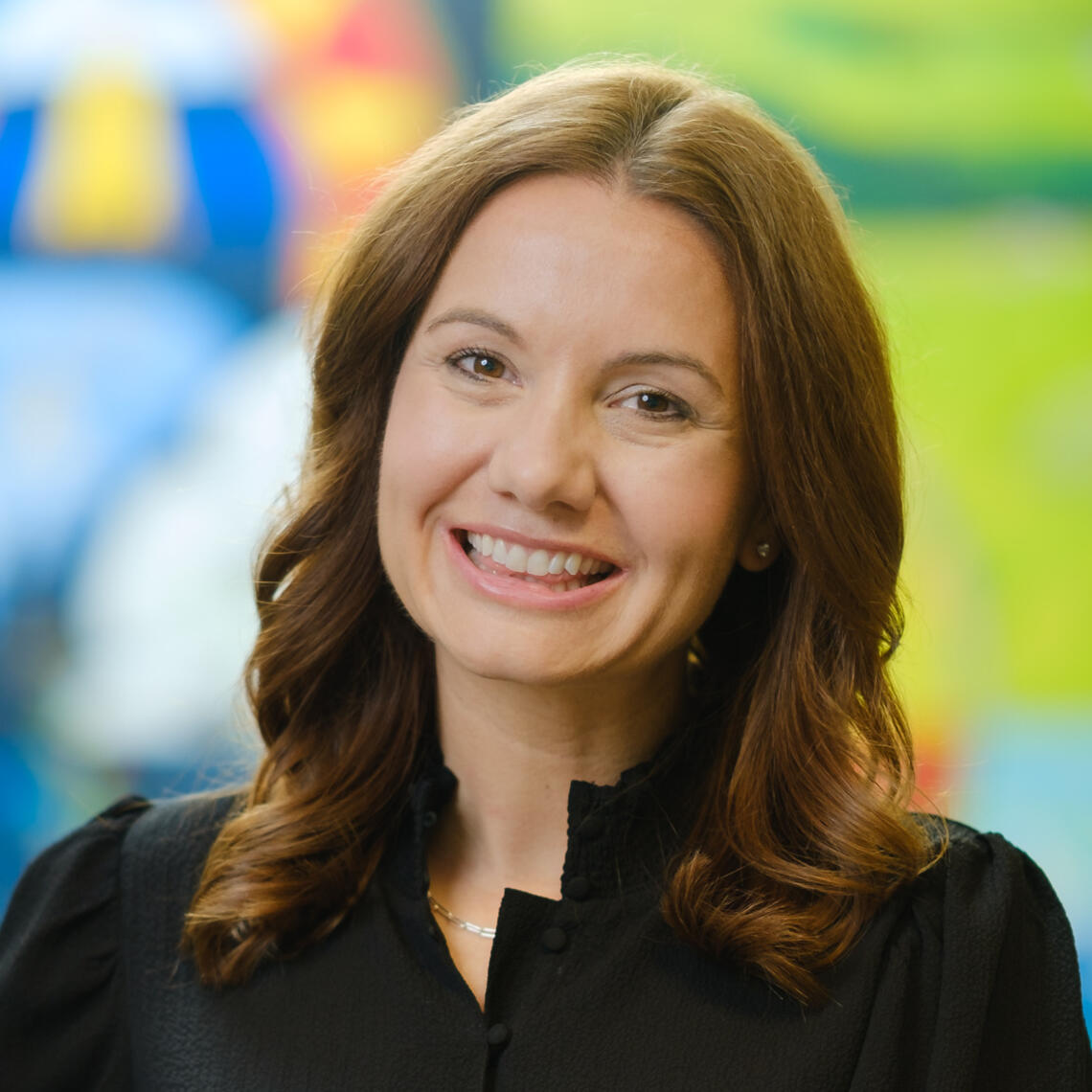 Sara Scott, PhD Candidate, smiling in a professional headshot with a blurred outdoor background