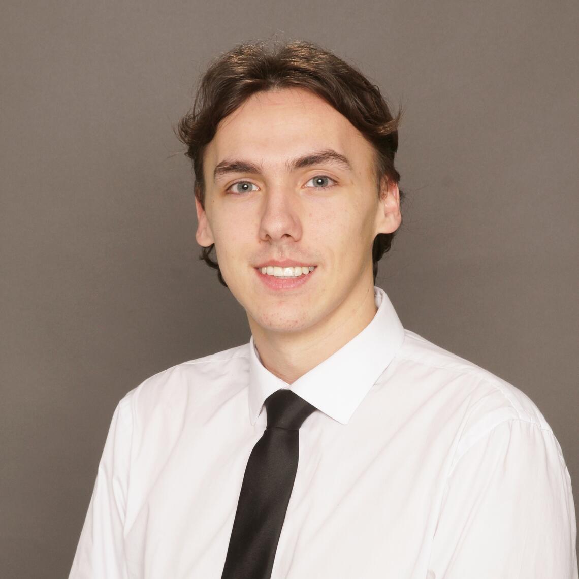 Tucker Reed, Master's Student, smiling in a professional headshot with a neutral background