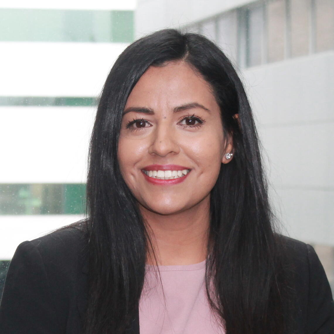 Kokab Younis, Master's Student, smiling in a professional headshot with a blurred building in the background