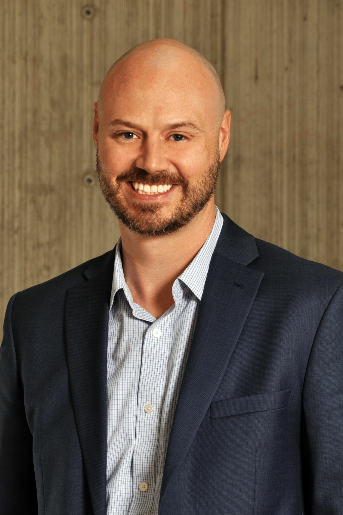 Professional photo of Dr. David Campbell. Male, bald, with a beard. Wearing a collared shirt under a navy blue jacket. 