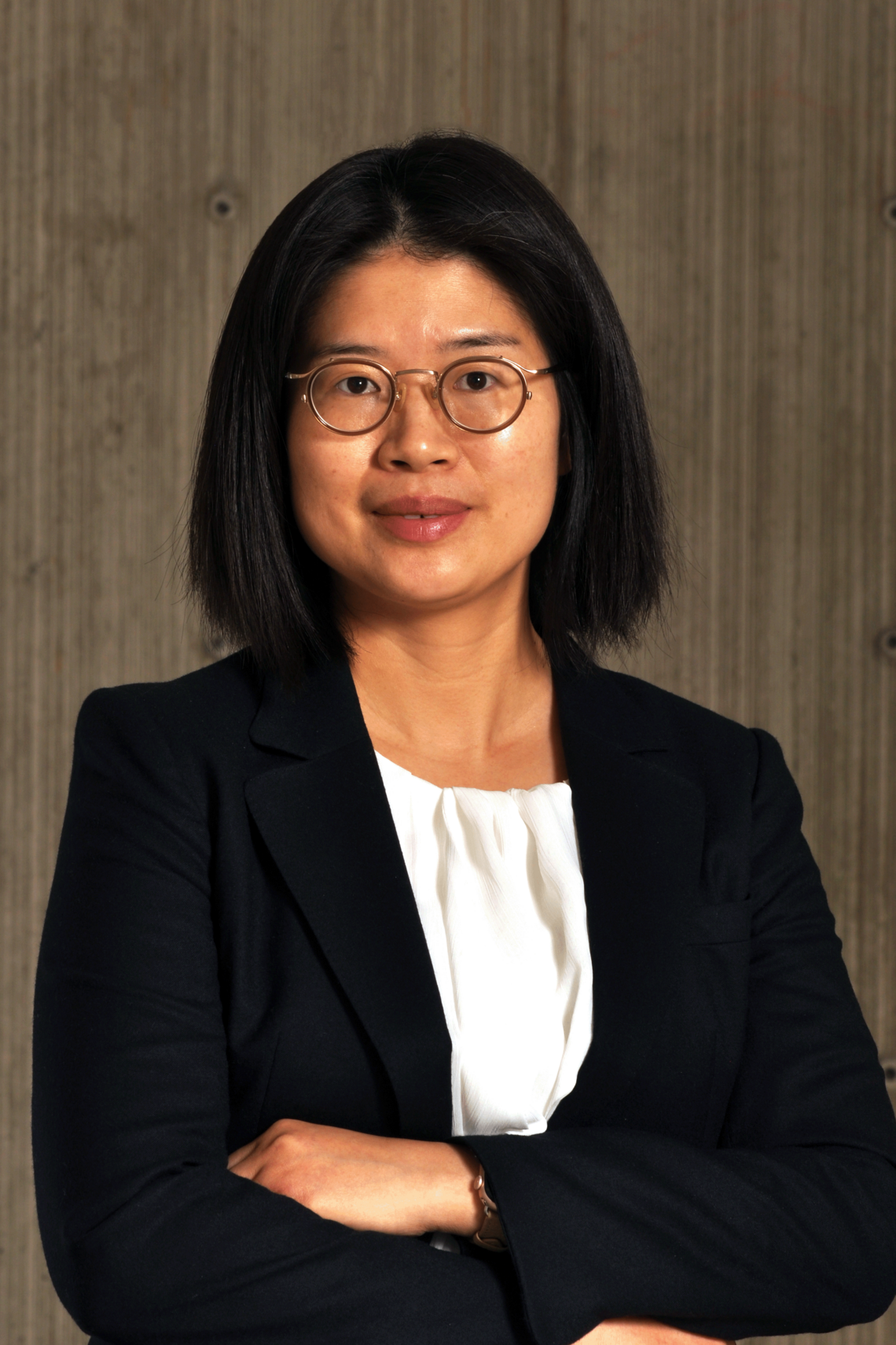 Professional photo of Dr. Ping Liu, female, shoulder length black hair. Wearing a black jacket, and white shirt. She has her arms crossed and has glasses on.