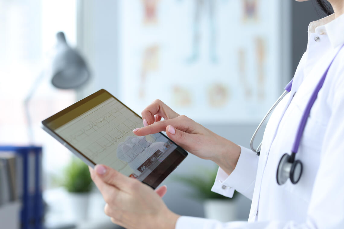 A doctor holding an Ipad reviewing lab values