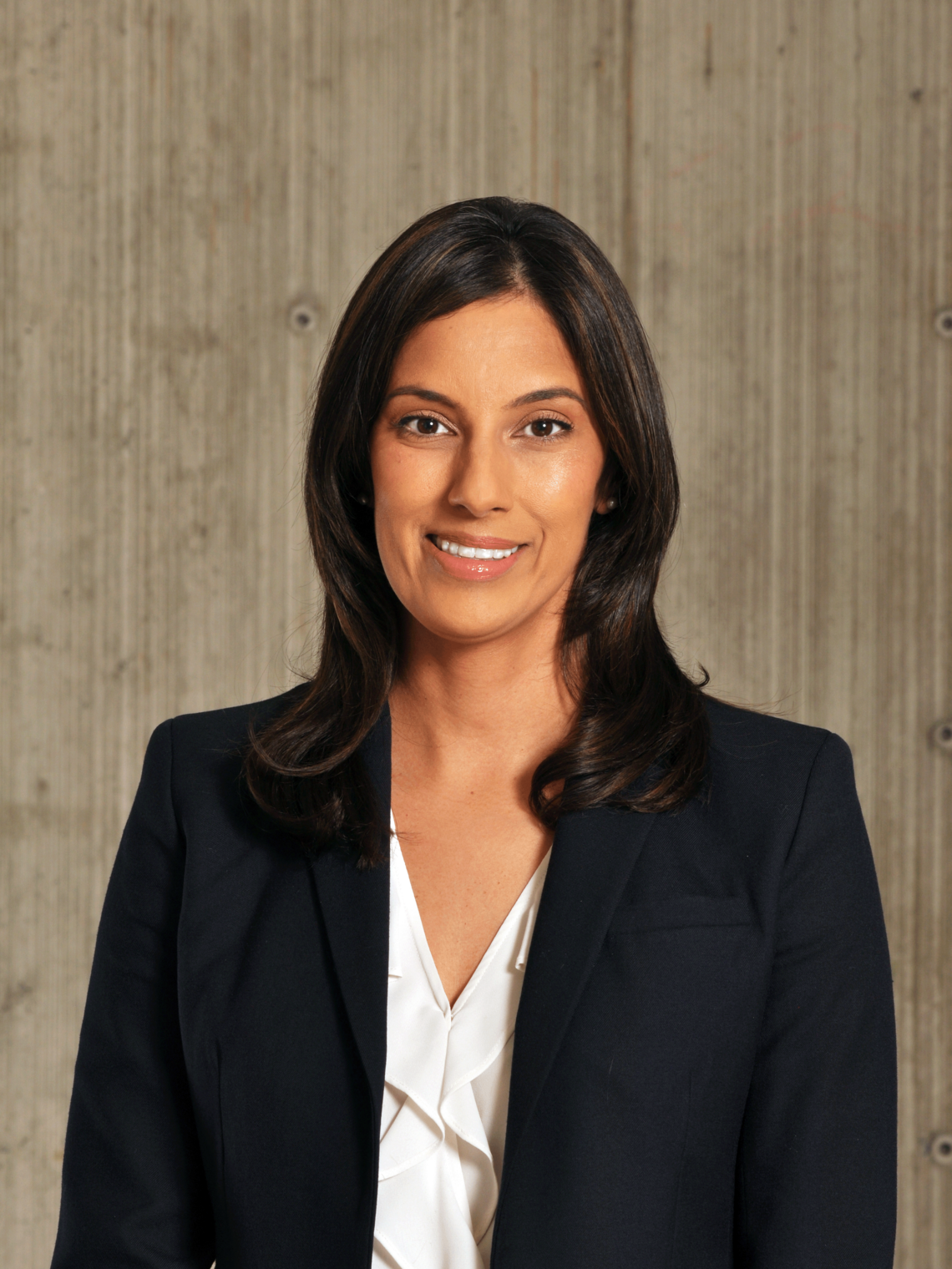 Dr. Sonia Butalia professional photo. She has her hair down, and and wearing a black jacket with a white shirt underneath. Photo is waist up.